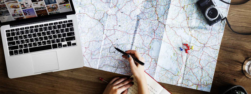 Woman planning a travel adventure with a map spread over a table
