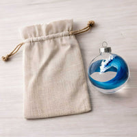 bluewater glass wave ornament beside unbranded canvas gift bag