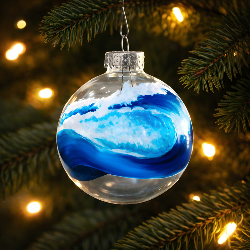 hand-painted bluewater glass wave ornament hanging on lit christmas tree branch