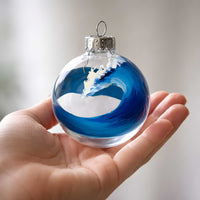 hand-painted bluewater wave ornament held in hand showing small scale