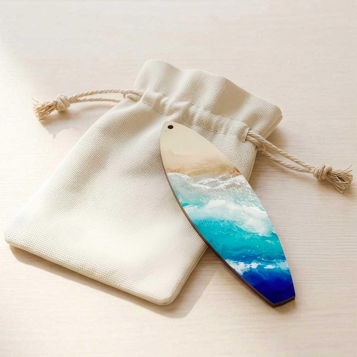 castaway surfboard ornament displayed with canvas drawstring bag that the ornament ships in