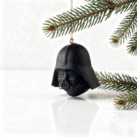 darth vader helmet holiday ornament hanging on christmas tree branch for star wars fans