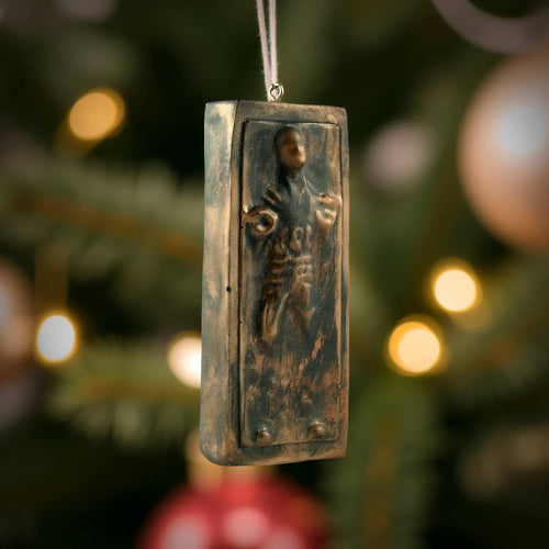 Han Solo in carbonite ornament hanging on christmas tree with warm holiday lights