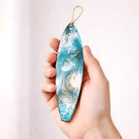 Islander surfboard ornament shown in hand for size reference