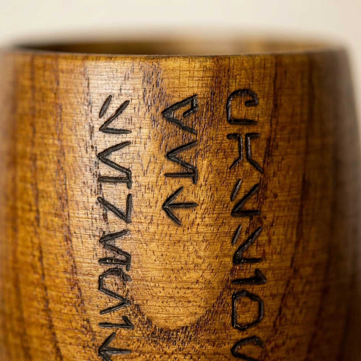 Close-up of hand-burned Aurebesh Jedi Code text on a handcrafted wooden Kar’tam cup