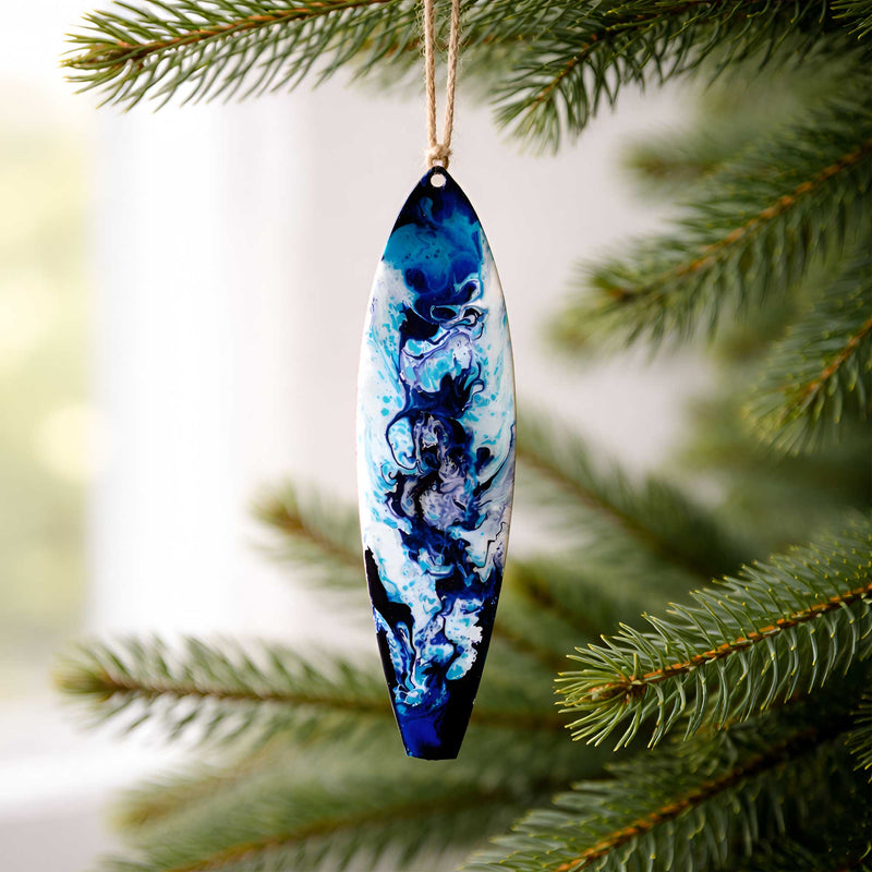 Let It Flow surfboard ornament hanging from a tree branch with fluid blue and white resin inspired by open water