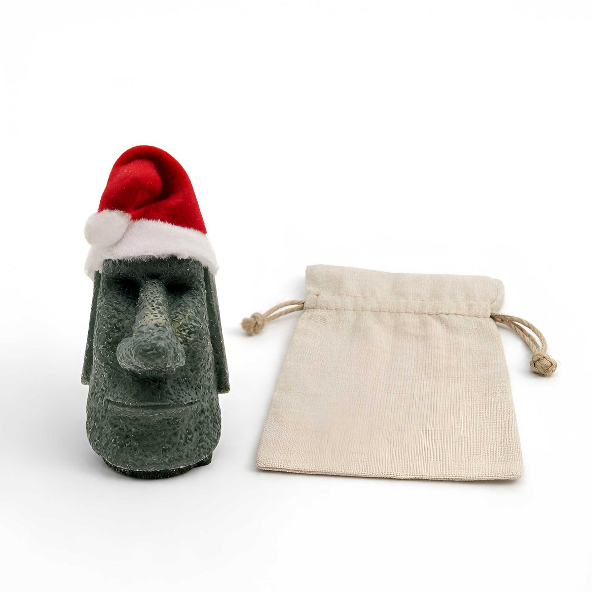 handmade jungle green tiki moai ornament with sculptural stone finish standing next to a canvas gift bag