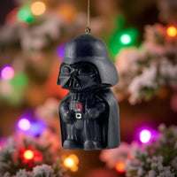 Mini Darth Vader ornament hanging on a Christmas tree with festive holiday lights.