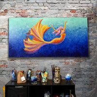 Mischief mermaid painting displayed on a rustic brick wall above studio shelves, showcasing large coastal artwork in a room.