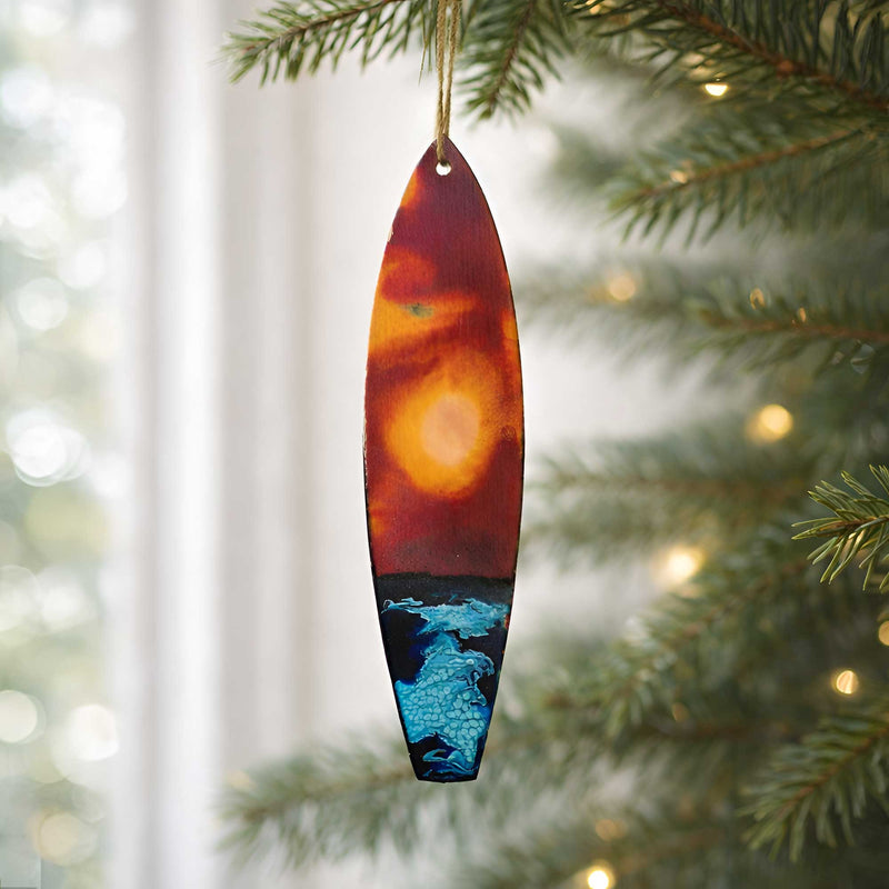 hand painted surfboard ornament hanging from a christmas tree branch
