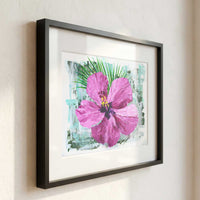 Framed pink hibiscus flower painting displayed in bright modern coastal interior with neutral decor