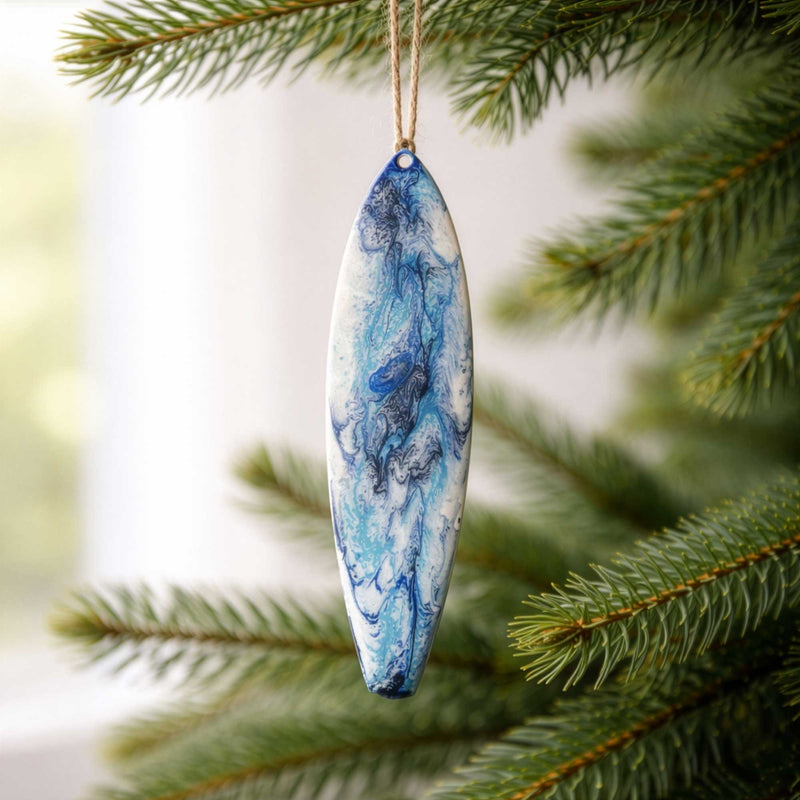 Seaside Soul surfboard Christmas ornament hanging on evergreen tree branch