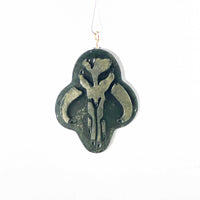 Mini Mythosaur Crest ornament hanging in front of a white background