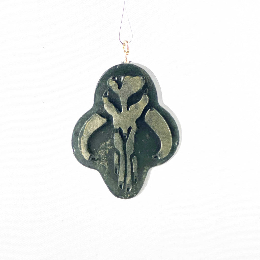 Mini Mythosaur Crest ornament hanging in front of a white background