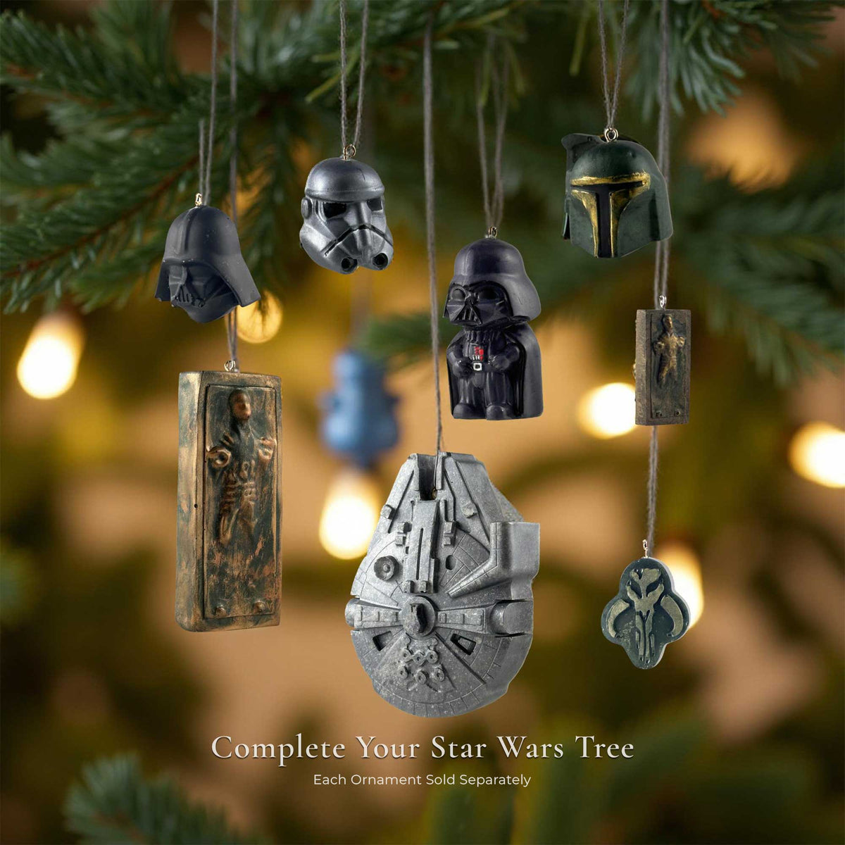 Star Wars resin Christmas ornaments hanging on a tree, including Darth Vader, Stormtrooper, Boba Fett, Millennium Falcon, Han Solo in carbonite, and Mythosaur designs.