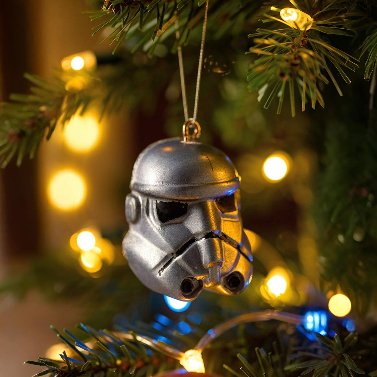 Stormtrooper helmet ornament hanging on a Christmas tree.