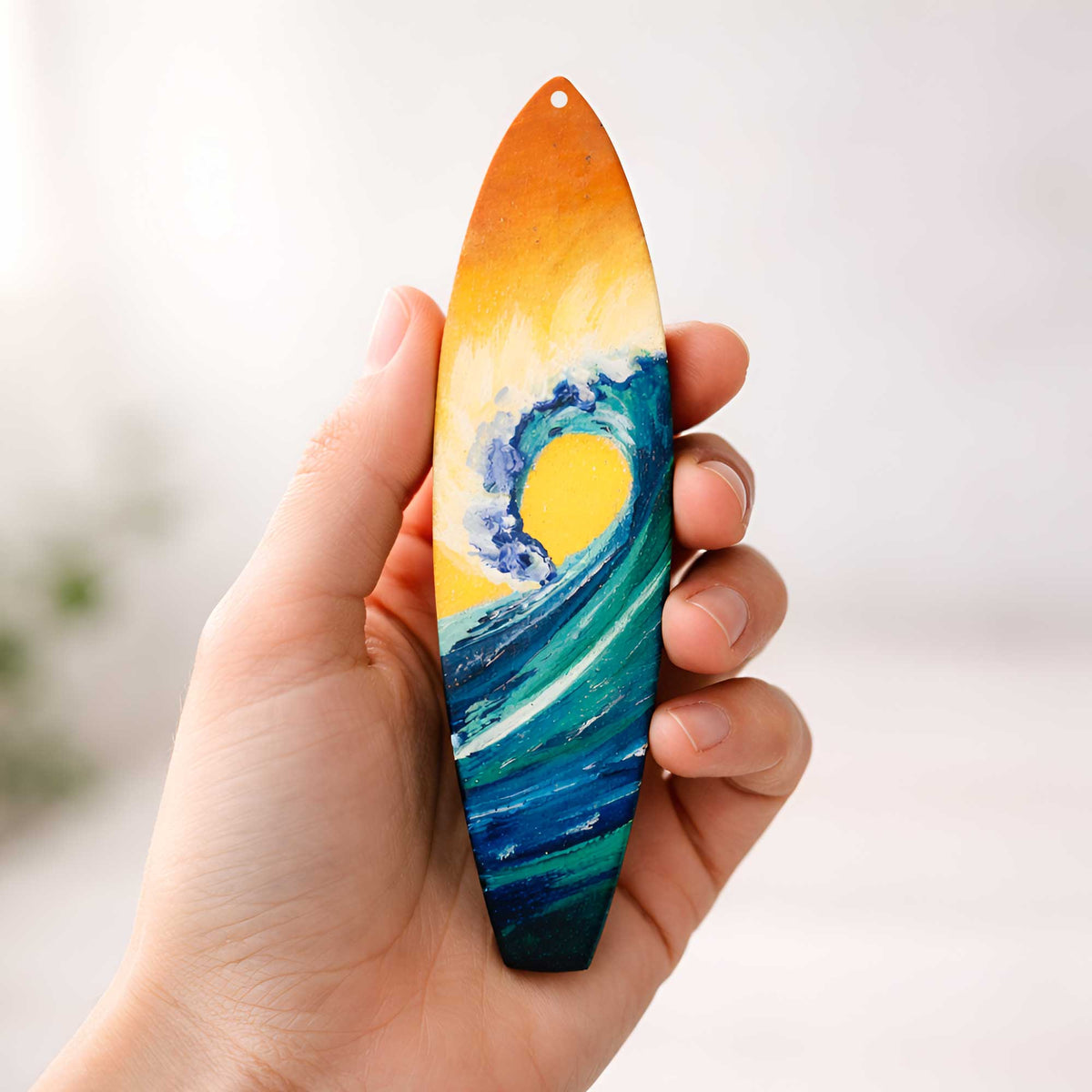 sunrise surfboard ornament shown in hand for size reference