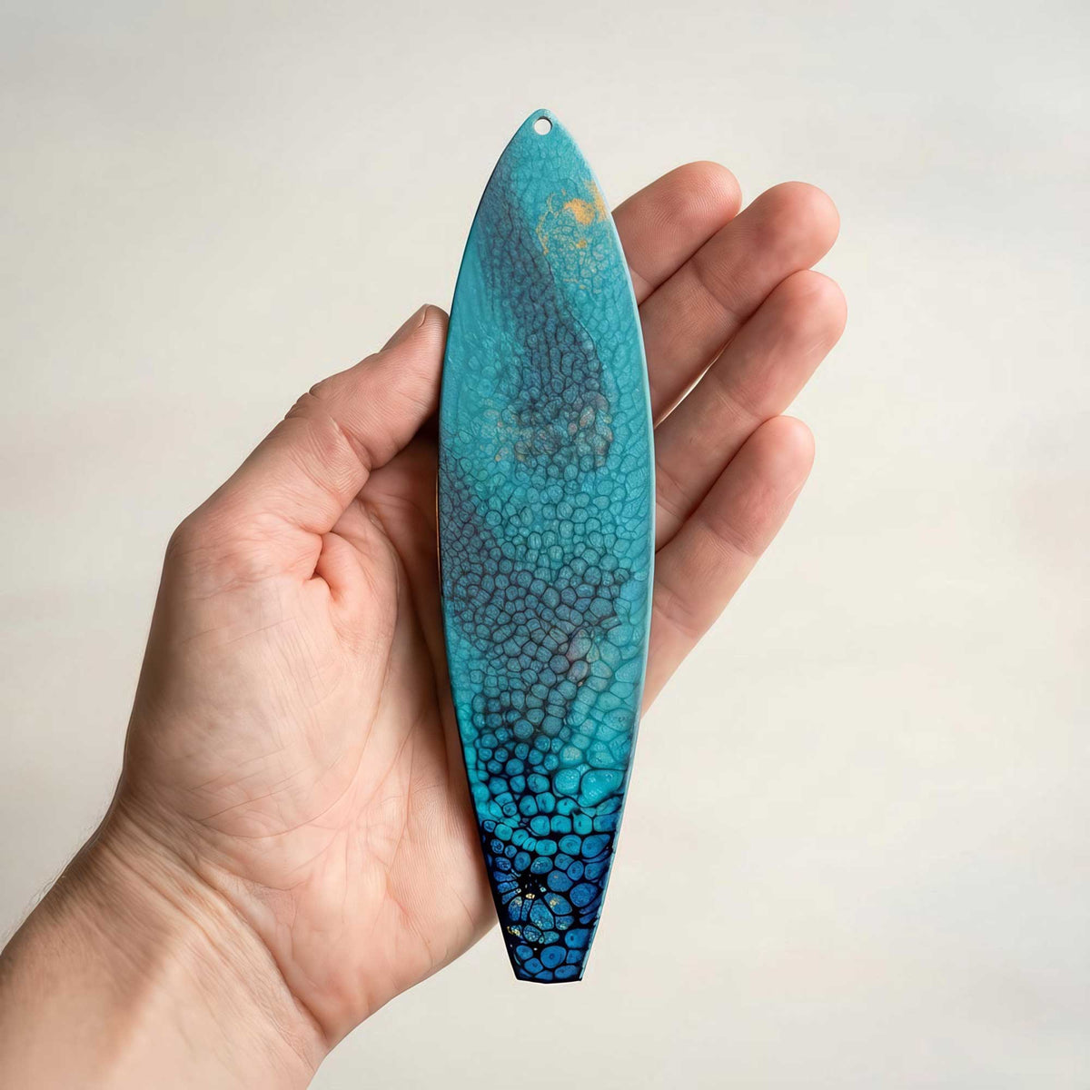 surf n’ stars surfboard ornament shown in hand for size reference