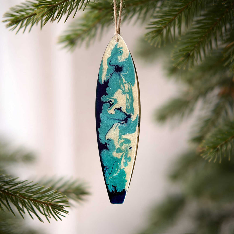 washed ashore by the sea surfboard ornament hanging on a christmas tree branch