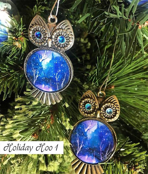 Silver and bronze owl Christmas tree ornaments with blue and white painted chests and swirled eyes.