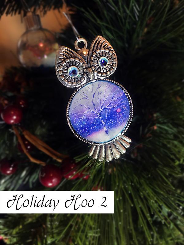Silver Christmas tree ornament shaped like owl with blue swirled eyes and painted Christmas tree stomach.