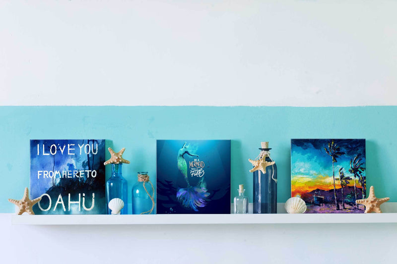 3 beach prints on small shelf with ocean and beach house décor, including Hawaiian, mermaid, and SoCal paintings