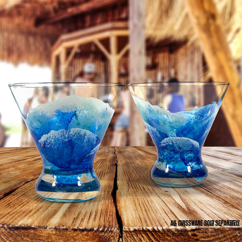 Pair of custom martini glasses sitting on a tiki bar, with beach bar or beach house decor in the background.