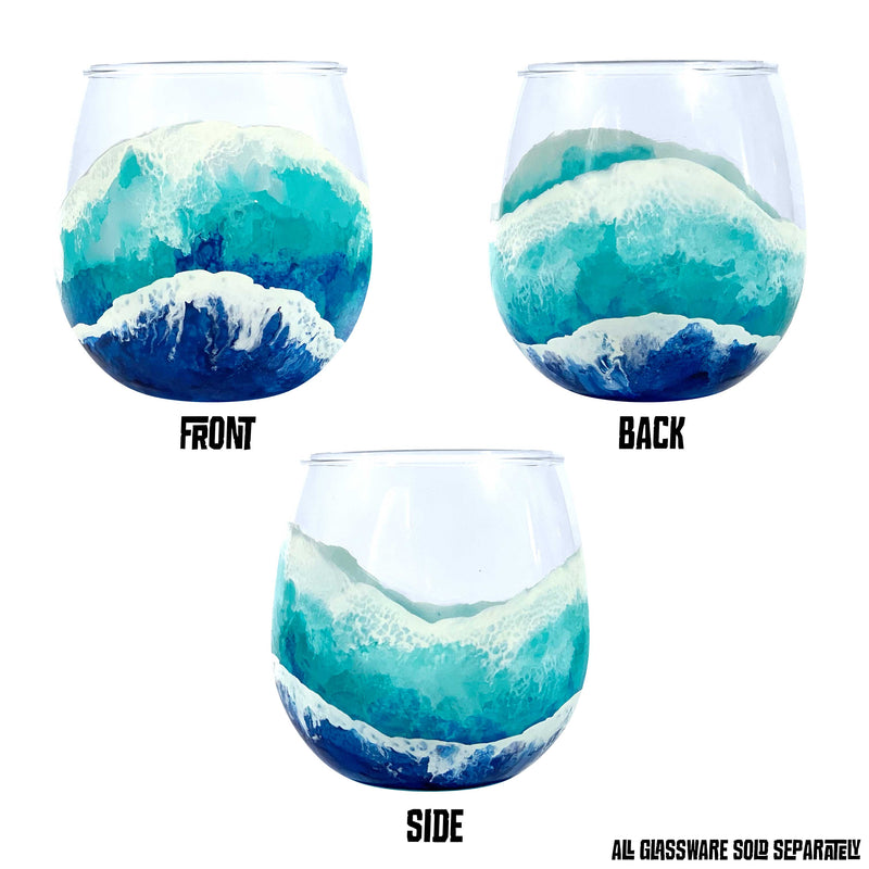 Beach themed glassware of hand-painted surfing waves washing up a stemless red wine glass. Beautiful beach barware, shown from 3 different sides.