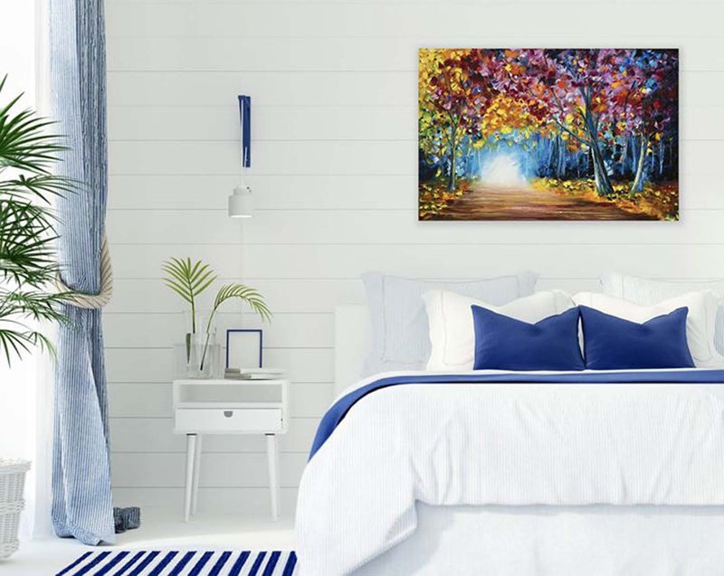 Large original oil painting of a colorful fall forest hung in a blue and white bedroom as minimalist fall decor for home.