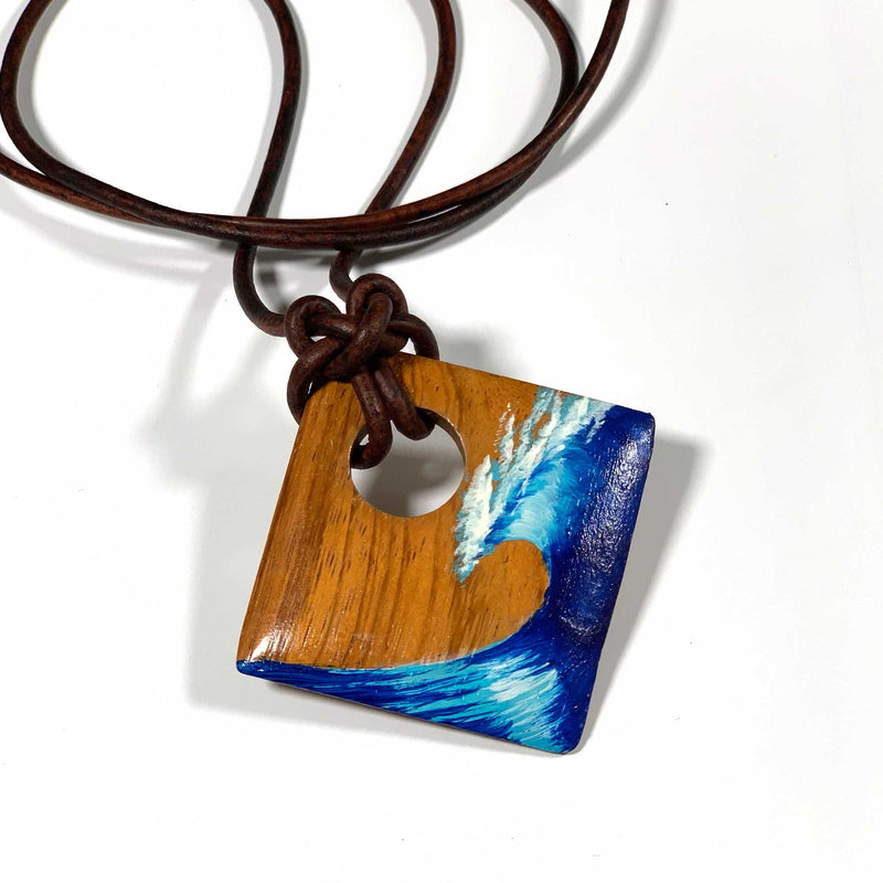 Diamond shaped wood pendant with a blue ocean wave painted on the front with an adjustable leather cord necklace