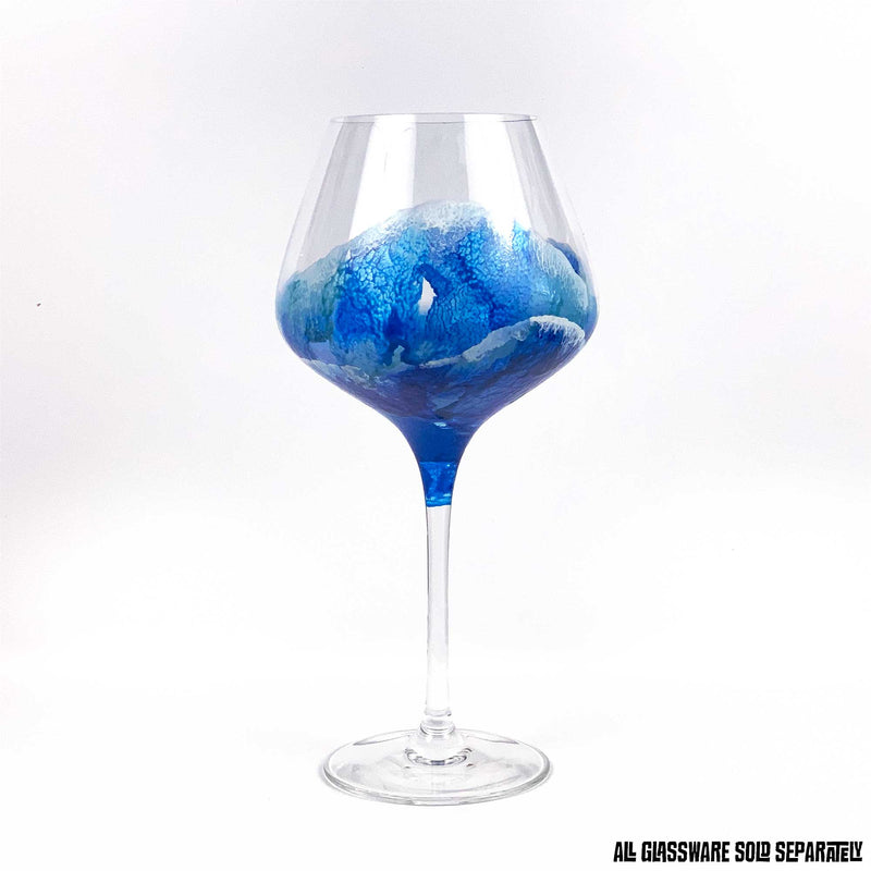 Custom glassware with hand-painted ocean waves washing up a red wine glass in blue and white.