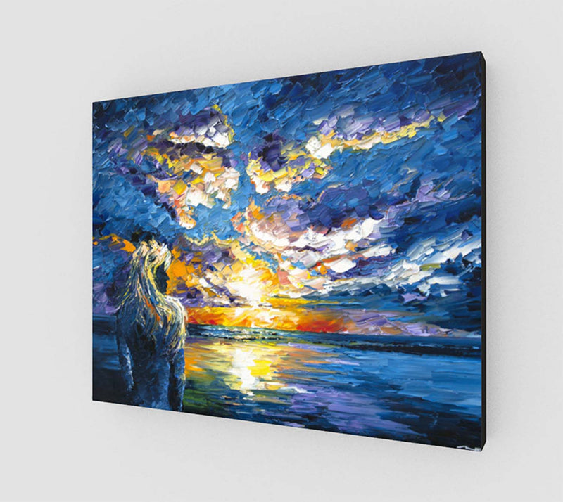 Stretched canvas print of a girl on the beach, watching the sunset over the blue ocean