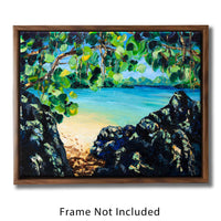 Beach house décor of a hidden tropical cove with clear turquoise water and green overhanging foliage on a white sand beach