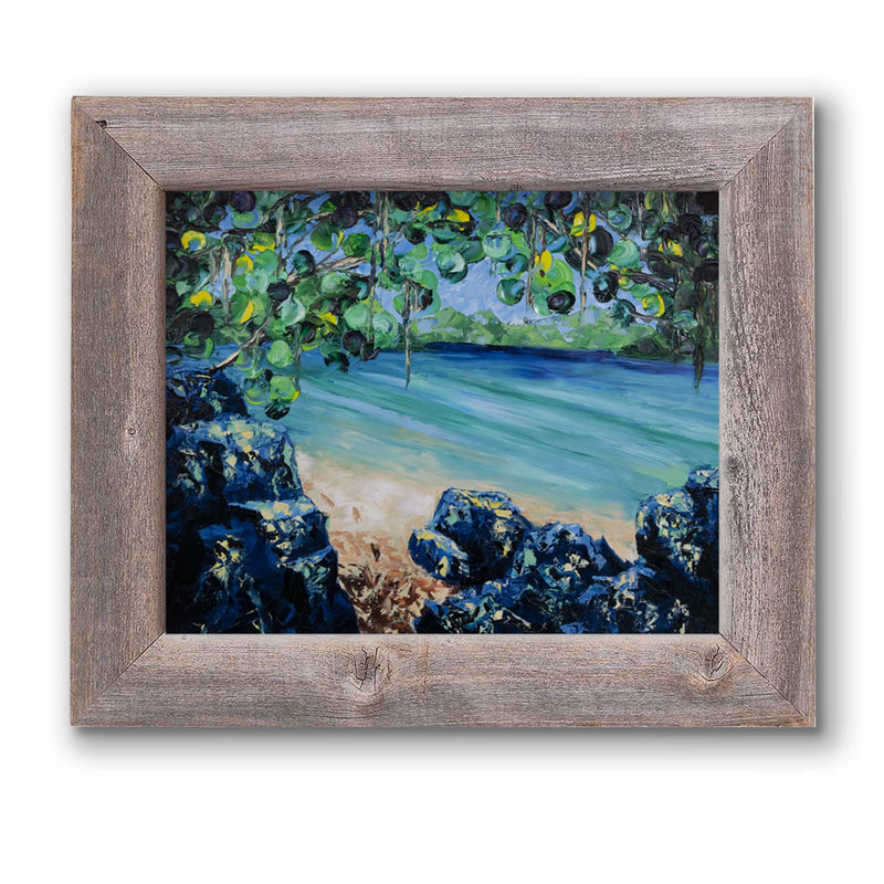 Framed beach house décor of tropical beach on a turquoise lagoon with lush green foliage