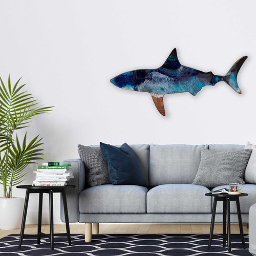 A living room with a wall art silhouette of a shark as a wooden art piece painted in blue and green resin like ocean waves