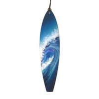 Surfboard holiday ornament with big blue wave painted on the front. Blue and white Christmas ornament on white background.