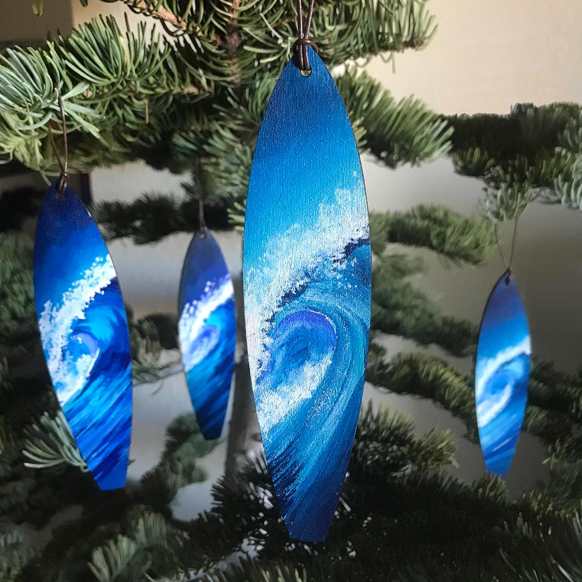 Set of blue and white ocean wave Christmas ornaments on a coastal-themed Christmas tree.