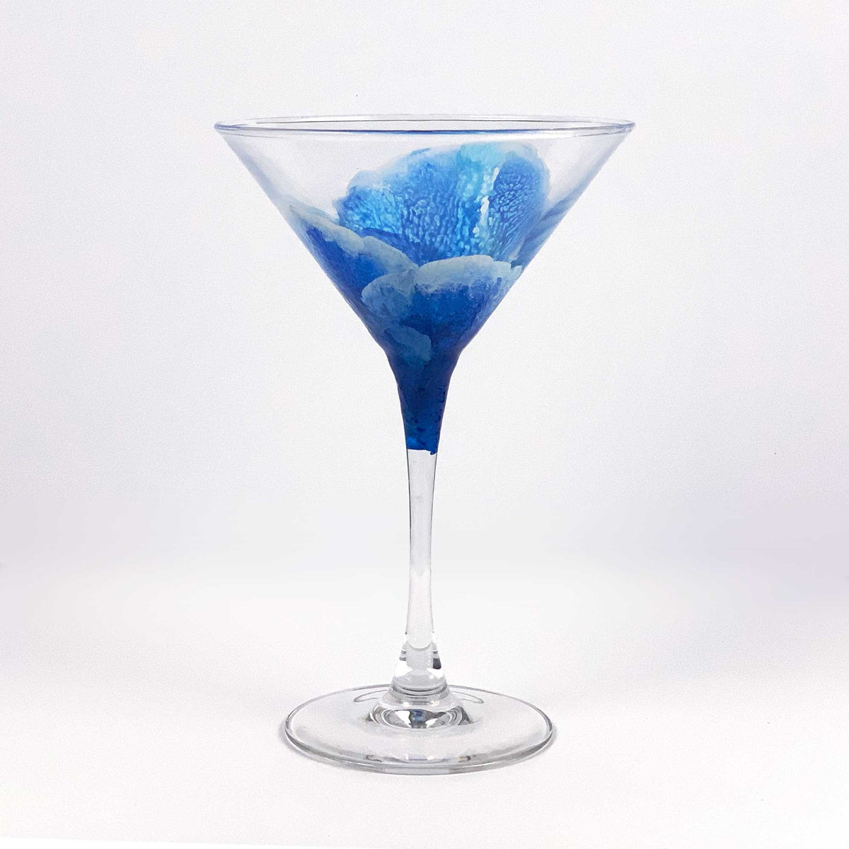 Contemporary blue martini glass with abstract ocean waves wrapping around the glass. Hand-painted blue and white translucent texture.