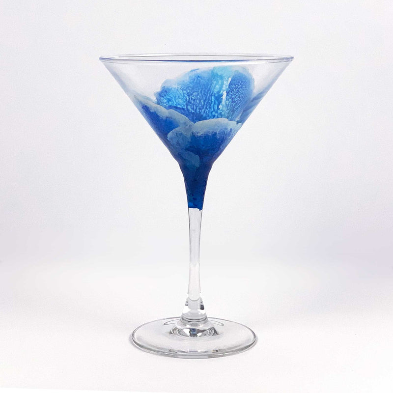 Contemporary blue martini glass with abstract ocean waves wrapping around the glass. Hand-painted blue and white translucent texture.