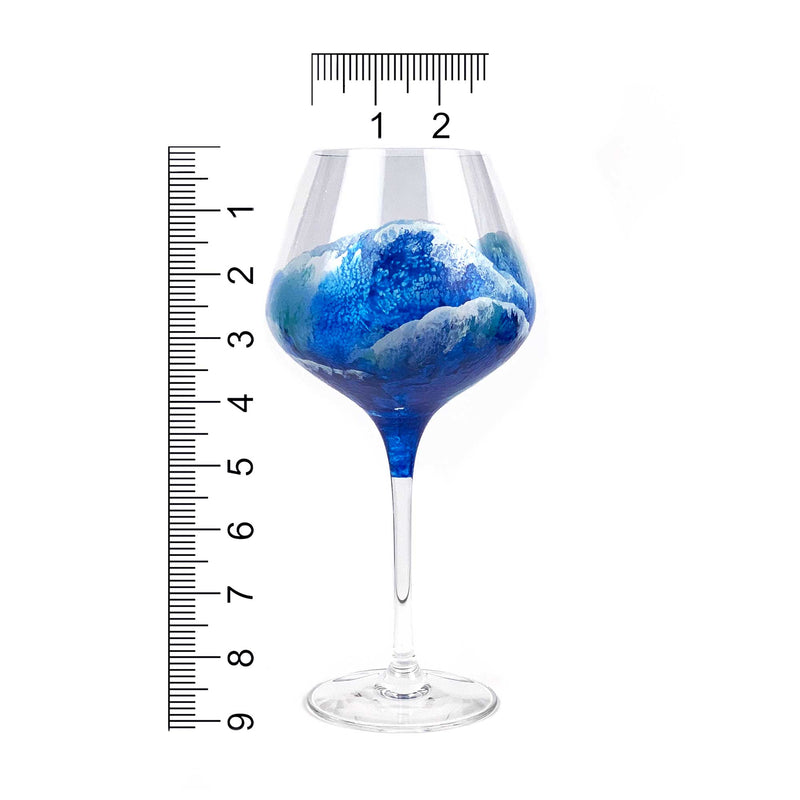 Single red wine glass of a beach barware set with hand-painted waves by 5th & Rugged. Shown with scale for size reference.